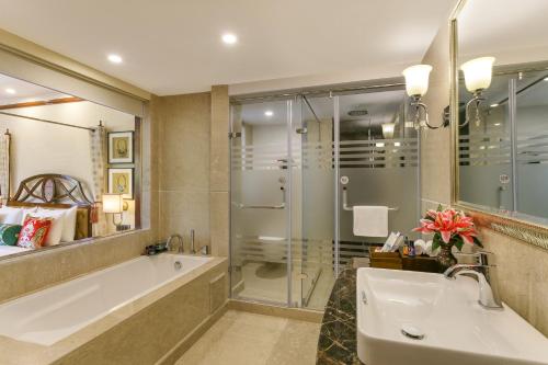 a bathroom with a tub and a shower and a sink at The Grand Dragon Ladakh in Leh