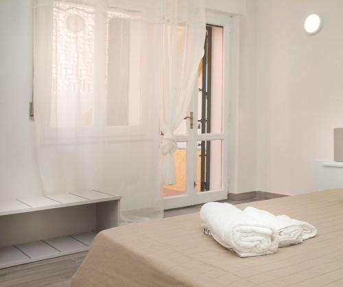 a white room with a bed and a window at I Viaggi di Ki in Santa Teresa Gallura