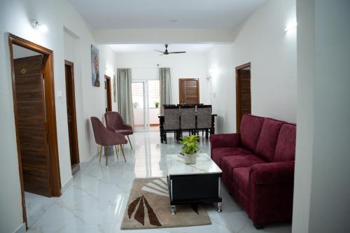 a living room with a red couch and a table at Yellow Bells Serviced Apartments Hitech City in Kondapur