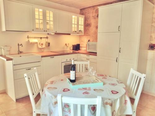 a kitchen with a table with a bottle of wine on it at Gîte du Moulin de Maître Pierre in Payrignac