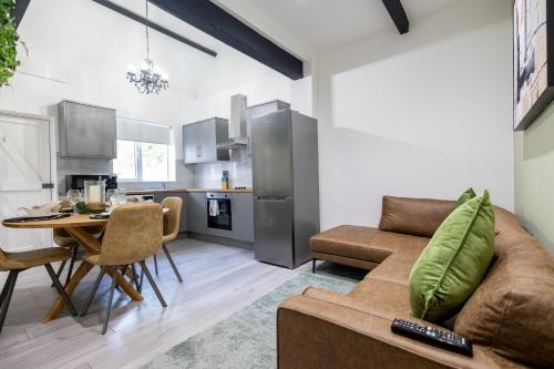 eine Küche und ein Wohnzimmer mit einer Couch und einem Tisch in der Unterkunft Charming Cottage Near Fields and Harry Potter Studios in Garston
