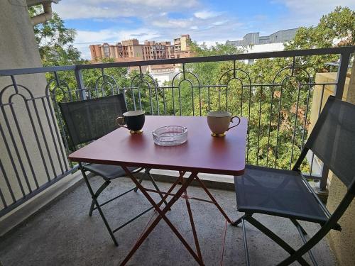 d'une petite table et de deux tasses sur un balcon. dans l'établissement T1 - 160 bed - city center, à Toulouse