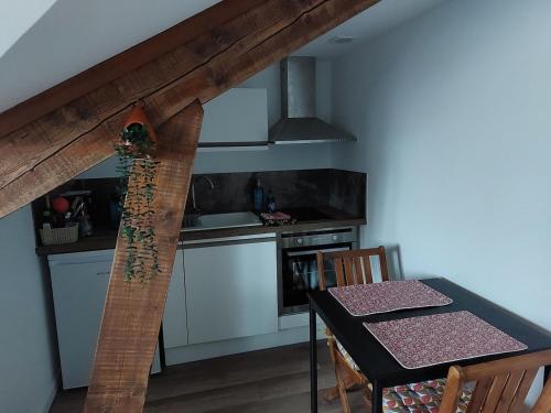 une cuisine avec une table et des placards blancs dans l'établissement Seul sous les toits de Dijon, à Dijon