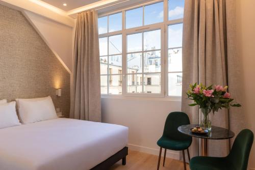 une chambre d'hôtel avec un lit et une fenêtre dans l'établissement Faubourg Station, à Paris