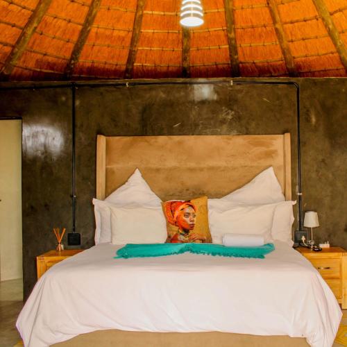a bedroom with a white bed with a picture of a woman at Imvomvo Country Lodge and Conference Center in Mount Ayliff