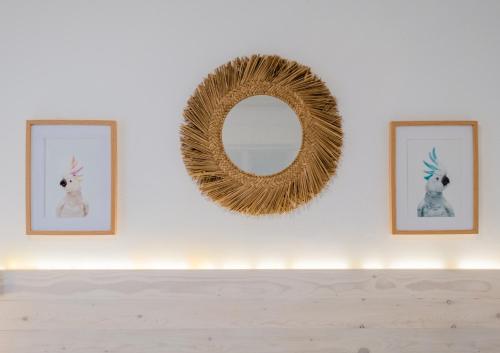 a mirror on a wall with two pictures of a dog at El Nogal Home in Málaga