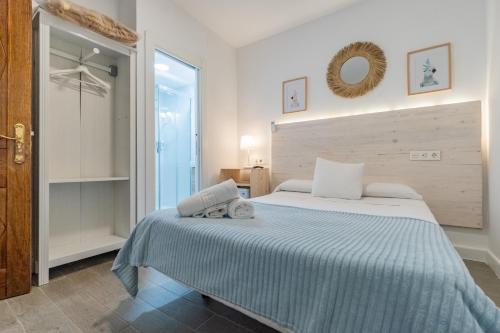 a bedroom with a large bed with a blue blanket at El Nogal Home in Málaga