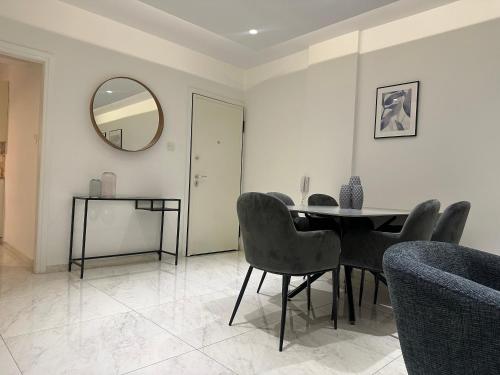 a dining room with a table and chairs and a mirror at Melia Suites in Limassol