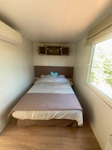 un lit dans une petite pièce avec une fenêtre dans l'établissement Domaine 3016, à Roquebrune-sur Argens