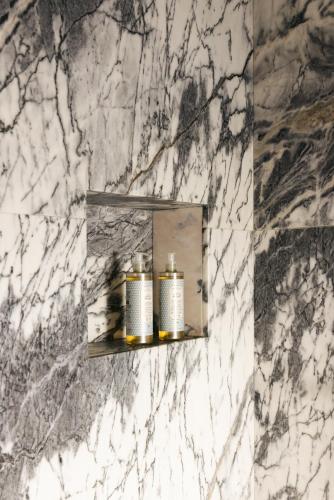 a bathroom mirror with two candles on a marble wall at Dare Lisbon River in Lisbon