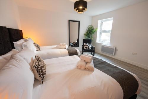 ein Schlafzimmer mit zwei Betten mit Handtüchern darauf in der Unterkunft Stylist 2-Bedroom Flat - Watford Central in Watford
