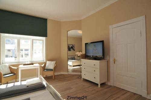 a living room with a television on a dresser at Gästehaus Cafe Orth Zimmer 21 in Westerland (Sylt)