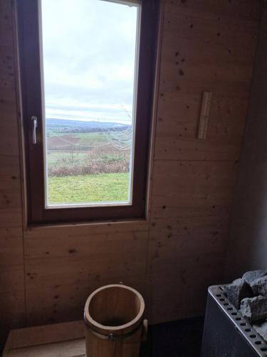 a window in a room with a trash can at Ferienhaus Mirzenberg in Mardorf