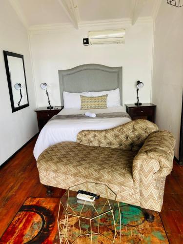a hotel room with a bed and a couch at Le Bamboo Guest House And Boat Cruise in Hartbeespoort