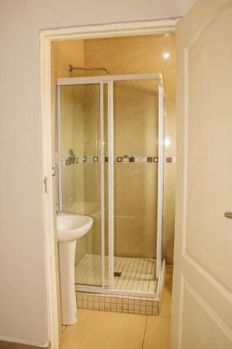 a bathroom with a shower and a sink at Imvomvo Country Lodge and Conference Center in Mount Ayliff