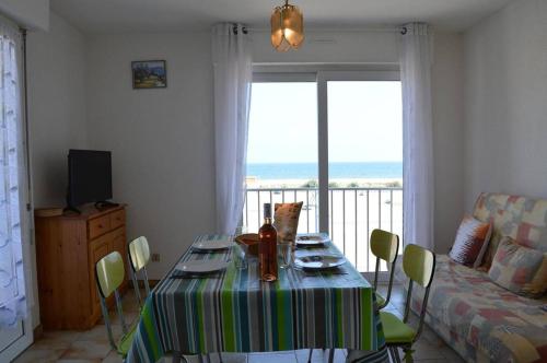 - un salon avec une table et une vue sur l'océan dans l'établissement SP240-011 Appartement 2 pièces SAINT PIERRE LA MER, à Saint Pierre La Mer