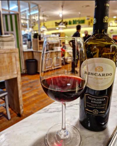 a glass of red wine next to a bottle of wine at ALBERGO 900Strati in Bergamo
