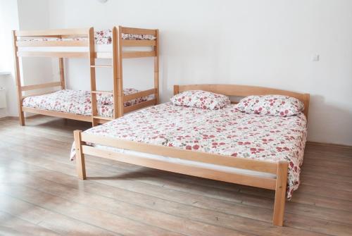 Apartment Bon Voyage في ماريبور: غرفة نوم بسريرين بطابقين وارضية خشبية