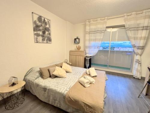 una camera da letto con un letto e una grande finestra di Studio cosy à deux pas de la mer 2LAMP36 a Le Barcarès