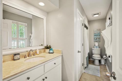 ein Badezimmer mit Waschbecken, Spiegel und Toilette in der Unterkunft Village Retreat - 100 Mews Circle in King City