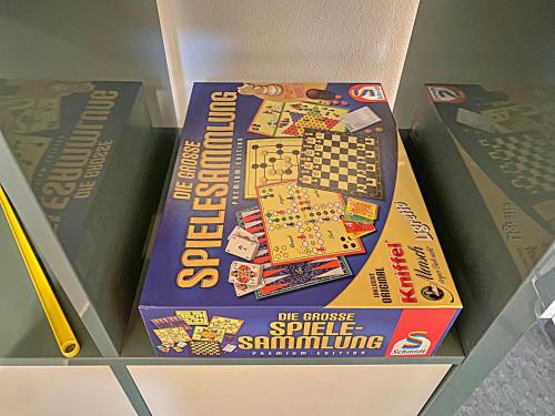 a monopoly board game is on a shelf at !GoldPath! Loft - Exclusiv - XXL - Central - Sauna - Tiefgarage - Cozy in Waldkirchen