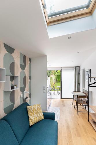 un salon avec un canapé bleu et une fenêtre dans l'établissement Studio à toutes proximités, à Bry-sur-Marne