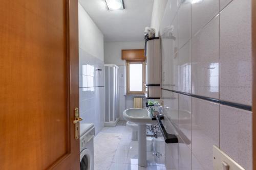 a white bathroom with a sink and a mirror at Casa Bellavista in Siderno Marina