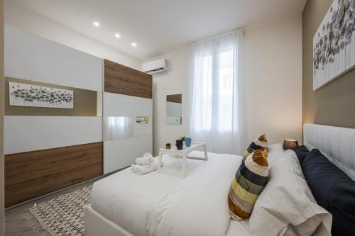 una camera da letto con un grande letto bianco e un gatto seduto sopra di Train Station Deluxe 3 Bath a Bologna