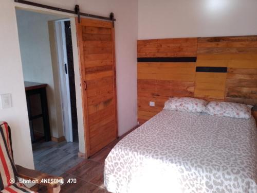 a bedroom with a bed with a wooden headboard at Lo de tina in Florencio Varela