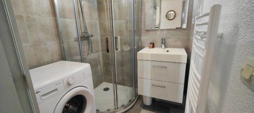 une salle de bain avec une machine à laver et un lavabo dans l'établissement Garden studio 150 m from the beach, à Fréjus