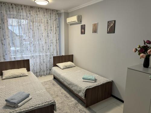 a room with two beds and a window at Samal Hostel in Gornyy Gigant