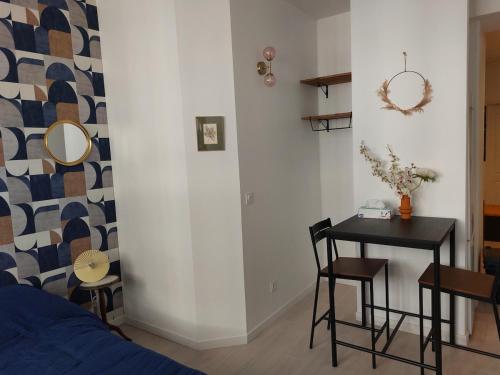 - une chambre avec une table, un lit, une table et des chaises dans l'établissement Le boudoir - Wi-Fi - TV, à Dijon