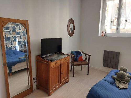 une chambre avec un lit, une télévision et un miroir dans l'établissement Le boudoir - Wi-Fi - TV, à Dijon