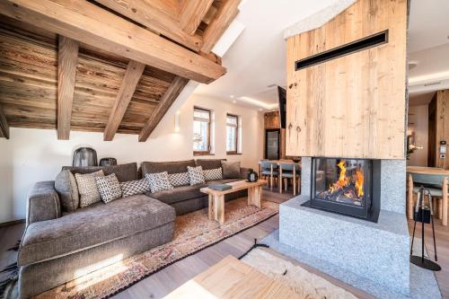 un salon avec un canapé et une cheminée dans l'établissement Chalet Vallon, Méribel - by EMERALD STAY, à Les Allues