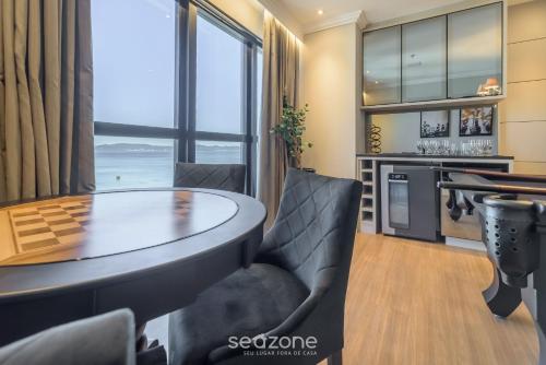 a dining room with a table and chairs at MHFs - Apts Variados em Prédio com Vista para o Mar em Itapema in Itapema