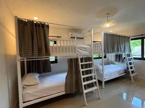 a room with two bunk beds and a bed at Purple House - Female only Boutique hostel in Koh Phangan