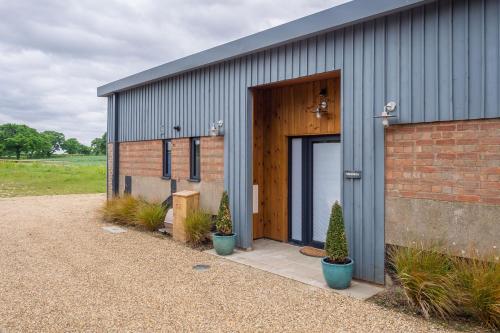 a gray building with a door and some plants at Mandalore 4 in Sotherton