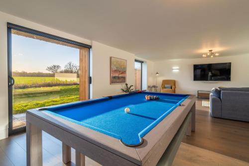 a pool table in a living room with a large window at Mandalore 4 in Sotherton