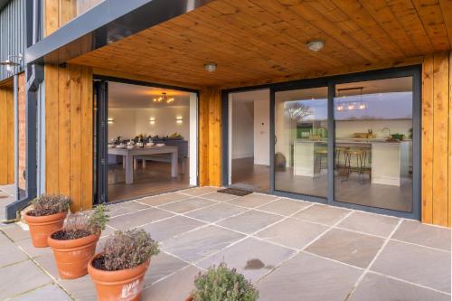 an outdoor patio with glass doors and plants at Mandalore 4 in Sotherton