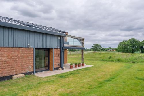a brick house with a glass roof on a field at Mandalore 4 in Sotherton