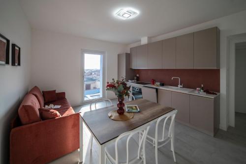 a kitchen and living room with a table and a couch at Residence - LA ROSA DEI VENTI in Ghedi