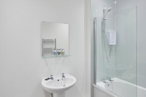a white bathroom with a sink and a shower at Zetland House Apt 4 in Loftus
