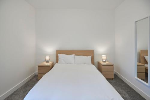 a bedroom with a large white bed with two lamps at Zetland House Apt 4 in Loftus