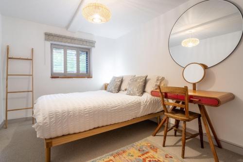 a bedroom with a bed with a mirror and a desk at Mill End by Big Skies Cottages in Weybourne