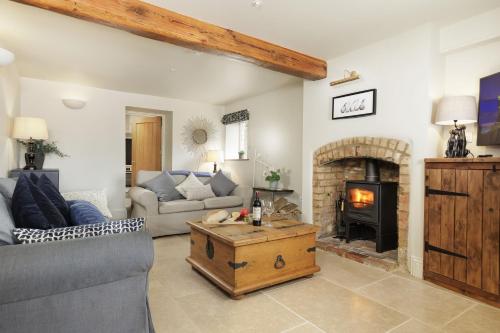 a living room with a couch and a fireplace at Longborough House in Moreton in Marsh