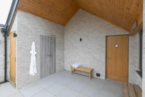 a porch with a wooden door and a bench at Captain's Walk in Newquay