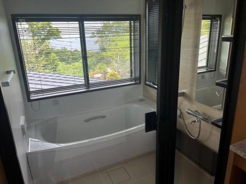 a bathroom with a bath tub and a window at Nokoshima Island Park Villa Sakimori in Fukuoka
