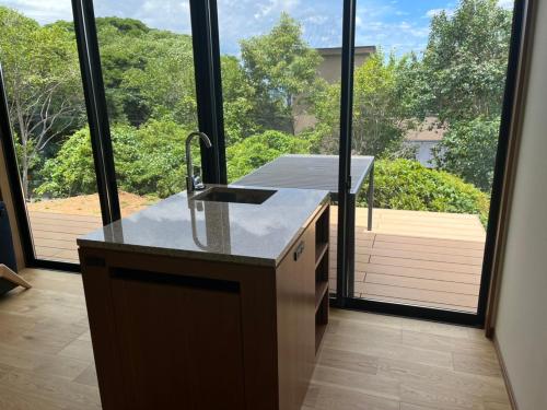 a kitchen with a sink and a large window at Nokoshima Island Park Villa Sakimori in Fukuoka