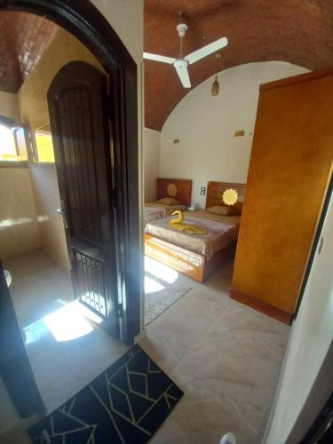 a view of a bedroom with a bed and a door at Nubian Soul Guest Houses in Aswan
