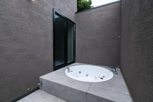 a bathroom with a bath tub with a window at Nokoshima Island Park Villa Sakimori in Fukuoka